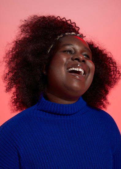 Young woman smiling wearing a blue jumper