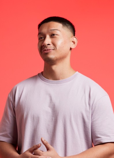 Young man smiling wearing a light pink t-shirt