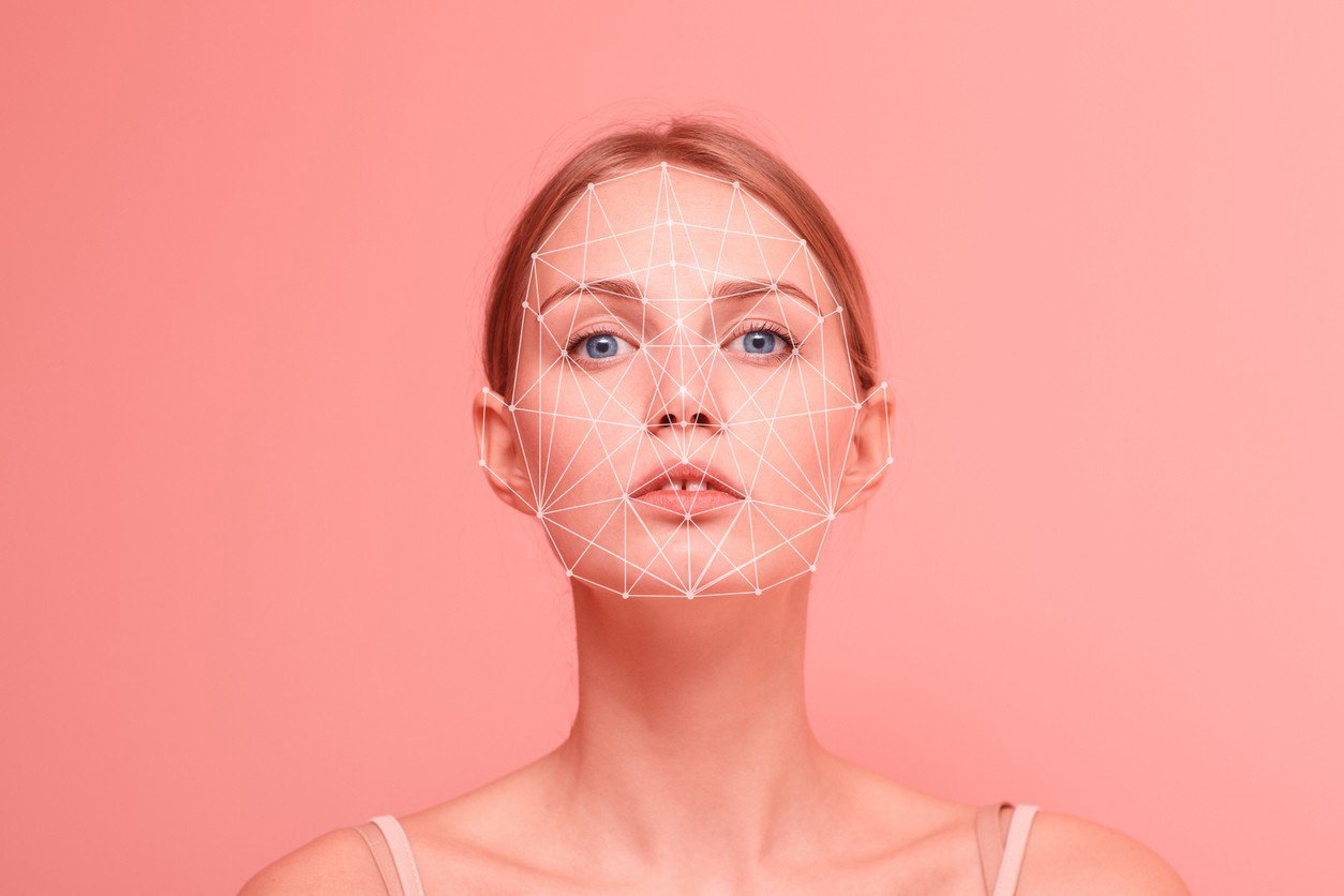 Woman on pink background with augmented reality measurements on her face